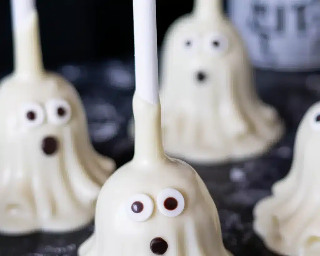 Spooky Halloween dessert pops decorated with chocolate and colorful sprinkles.
